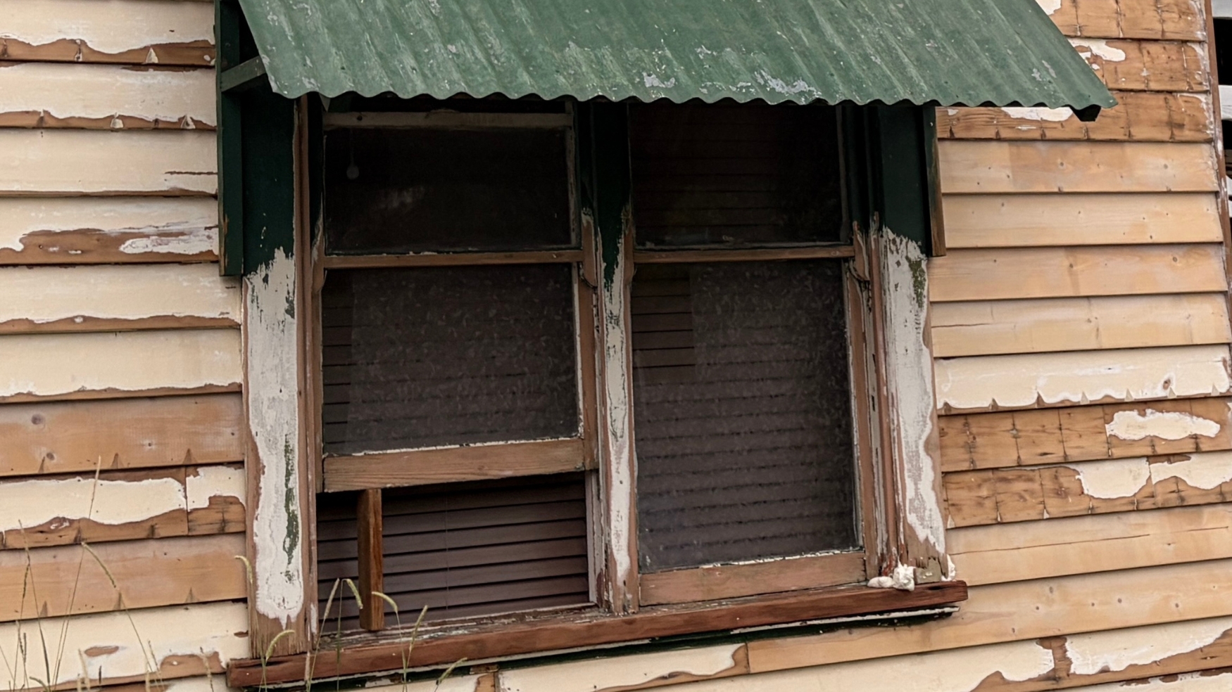 Timber window frame and weatherboards on a Clifton Hill home stripped back to bare timber by failed paint