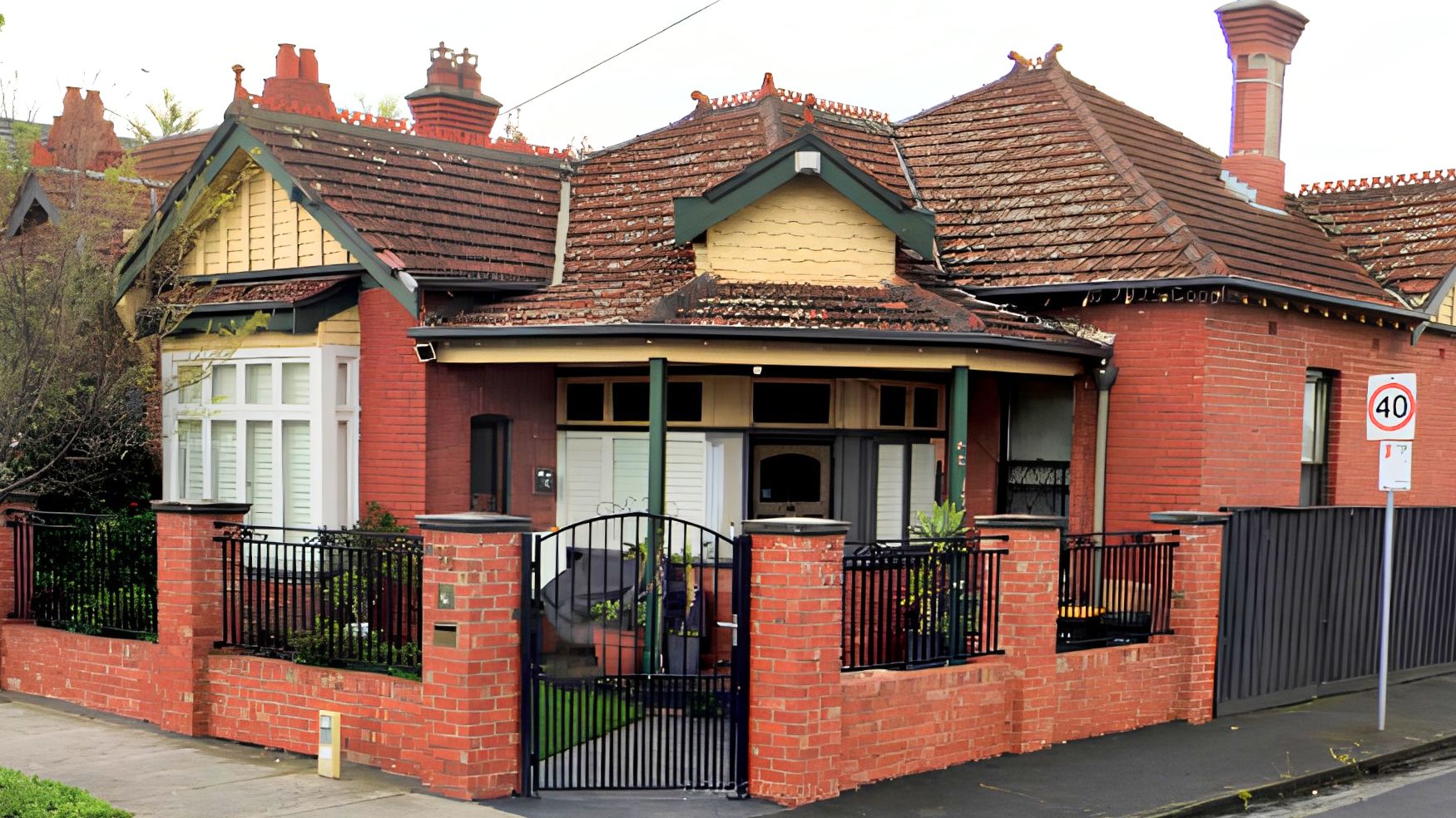 Red brick Edwardian home in Fairfield with timber shingled gable ends, verandah posts and window frames